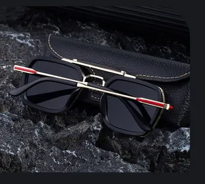 Close-up of square sunglasses with gold metal temples on a black stone background