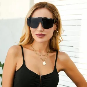 Macro detail of oversized shield sunglasses featuring white stripe accents and metal studs