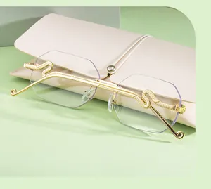 Détail macro de lunettes sans monture avec branches dorées gaufrées et étui rose doux