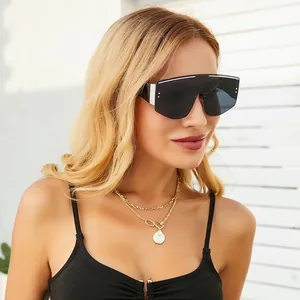 Detail of oversized shield sunglasses with white top bar and black lenses on model