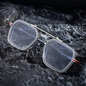 Square silver metal sunglasses with double bridge and red temple detail on dark rock
