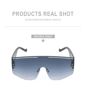 Close-up of modern oversized wrap-around sunglasses with gradient grey lenses and silver trim