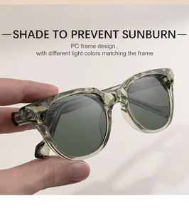 Gros plan de lunettes de soleil œil de chat vert olive avec verres gris à la main