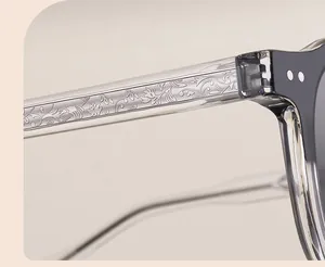 Detailed close-up of sunglasses side arm with engraved metal core and transparent resin