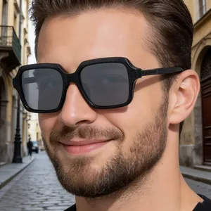Gros plan de lunettes de soleil carrées noires pour hommes avec verres foncés sur un modèle