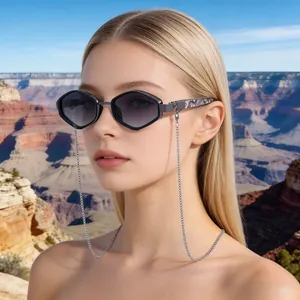 Close-up of geometric polygon sunglasses with silver chain on a model in a canyon