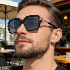 Détail de lunettes de soleil noires carrées avec charnières dorées portées par un homme