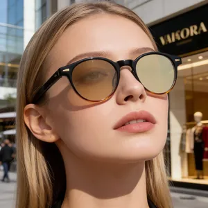 Outdoor-Porträt einer runden Sonnenbrille mit gelben Verlaufsgläsern und schwarz-braunem Gestell