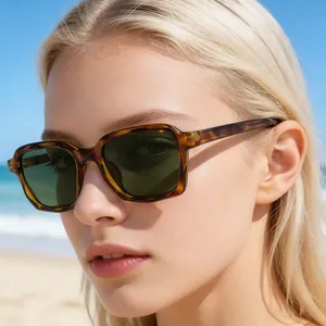 Nahaufnahme einer quadratischen Sonnenbrille in Schildpatt-Optik mit Strandhintergrund