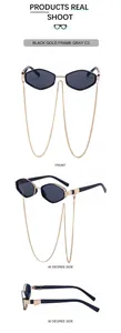 Detail view of hexagonal black gold sunglasses with decorative fine metal chain link