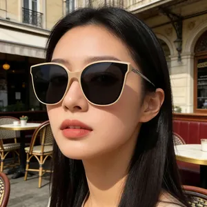 Gros plan de lunettes de soleil œil-de-chat beige avec verres foncés sur un modèle