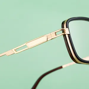 Detail view of square sunglasses with hollow gold metal temples and robust black frames