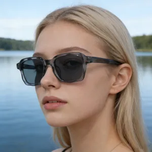 Nahaufnahme einer stylischen rechteckigen grauen Sonnenbrille, getragen von einem Modell