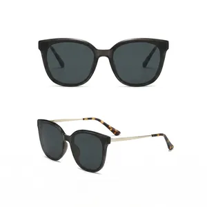 Lunettes de soleil polarisées œil de chat avec monture grise et branches dorées en deux vues