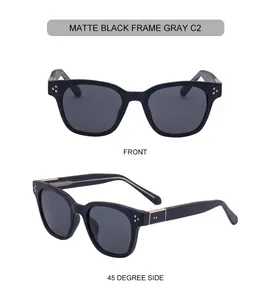 Detail view of matte black square sunglasses with grey lenses and metal rivet accents