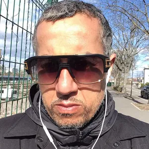 Détail de lunettes de soleil homme avec verres dégradés violets et barre dorée