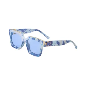 Lunettes de soleil carrées à texture marbre bleu avec verres bleus et détails dorés