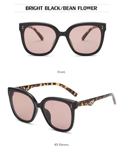Detail of bright black cat-eye sunglasses with tortoiseshell temples and metal accents