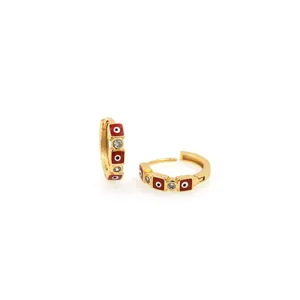 Close-up of 18K gold-plated evil eye earrings with red enamel and sparkling zircon stones