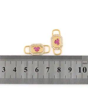 Makro-Detail von 18K vergoldeten Herz-Verbindern mit rosa Steinen für DIY-Schmuck