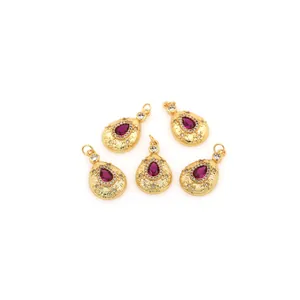 Detail of 18K gold-plated teardrop pendants with red stones and zircon accents