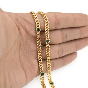 Detailaufnahme der 18K vergoldeten flachen Kette mit grünen herzförmigen Edelsteinen