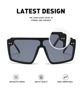 Détail de lunettes de soleil noires oversize avec doubles rivets métalliques sur le coin