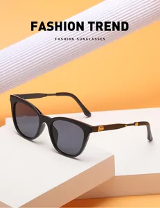 Detail of black cat-eye sunglasses with golden metal stripes on the side temple