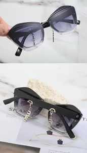 Détail de lunettes de soleil œil-de-chat avec pendentifs miu dorés et monture noire
