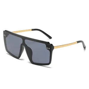 Lunettes de soleil carrées oversize avec monture noire, branches dorées et verres gris