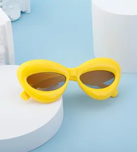 Macro detail of glossy yellow cat eye sunglasses with amber lenses on minimalist props