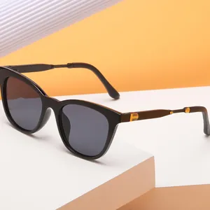 Stylish black cat-eye sunglasses with gold metal accents on white geometric blocks
