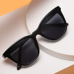 Chic black cat-eye sunglasses with dark grey lenses on geometric platform display