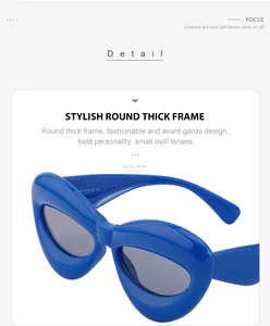 Detail of blue thick frame sunglasses with small oval lenses and fashion-forward design