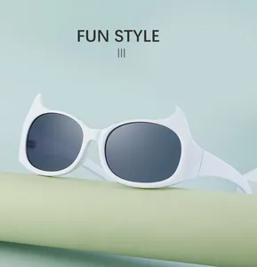 Détail des lunettes de soleil œil-de-chat blanches avec verres foncés sur socle vert