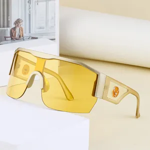 Lunettes de soleil Y2K à verre unique jaune et monture dorée sur pierre géométrique