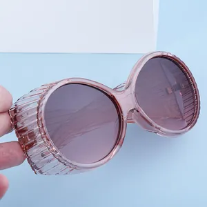 Detail view of oval sunglasses with pink frames and unique vertical striped side shields