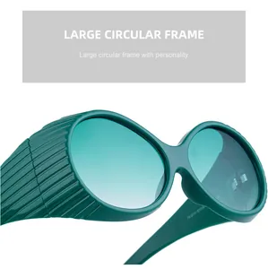 Close-up of oversized oval emerald green sunglasses with textured side shield design