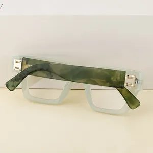 Primer plano de montura cuadrada verde menta con patillas jaspeadas y bisagra H dorada