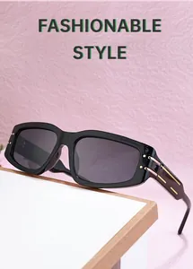 Detail of black rectangular sunglasses with golden metal accents on the temple