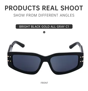 Front view of black rectangular sunglasses with golden rivets and grey lenses