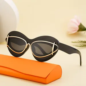 Chic black cat eye sunglasses with gold metal trim on a stylish orange leather case
