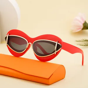 Fashionable red cat eye sunglasses with gold trim and orange hardshell glasses case