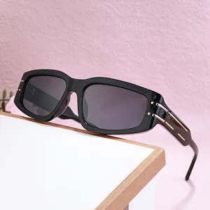 Classic black rectangular sunglasses with gold temple accents on a white minimal surface