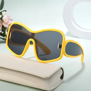 Oversize yellow shield sunglasses with dark lenses and beige leather case in a minimalist set