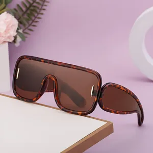 Lunettes de soleil oversize rétro écaille avec détails dorés sur un fond violet doux