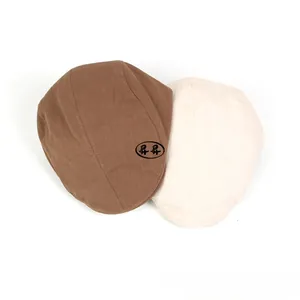 Flat cap detail showing woven cotton linen texture in coffee and beige colors