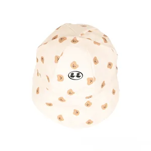 Detail of baby sun hat with brown cartoon bear prints and soft brim on white cotton