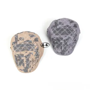 Détails de casquettes plates kaki et grises avec motif à losanges et imprimé graffiti