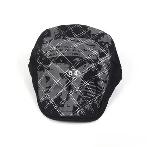 Détail de la casquette plate noire avec imprimé graffiti gris et motif losanges surpiqués